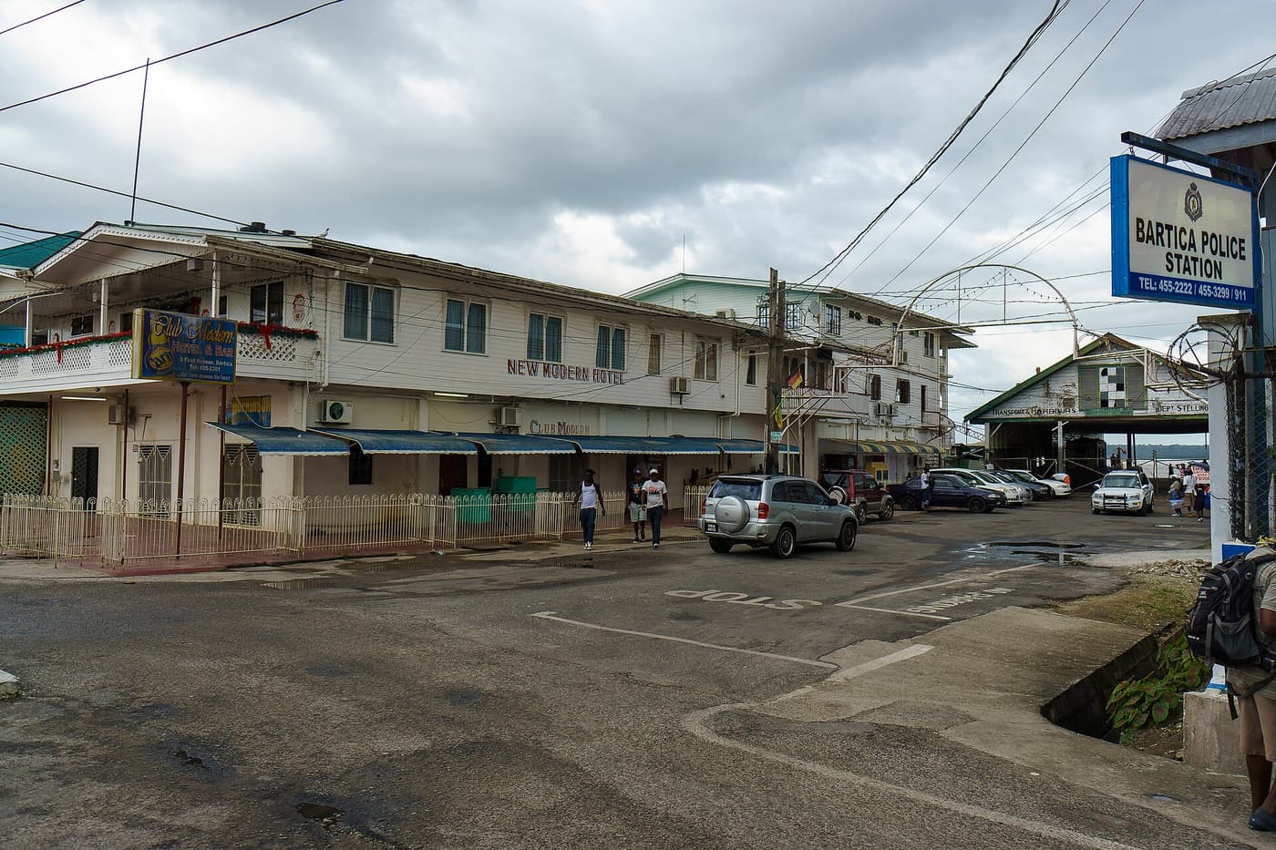 A street in Bartica with the police station and shops under a cloudy sky