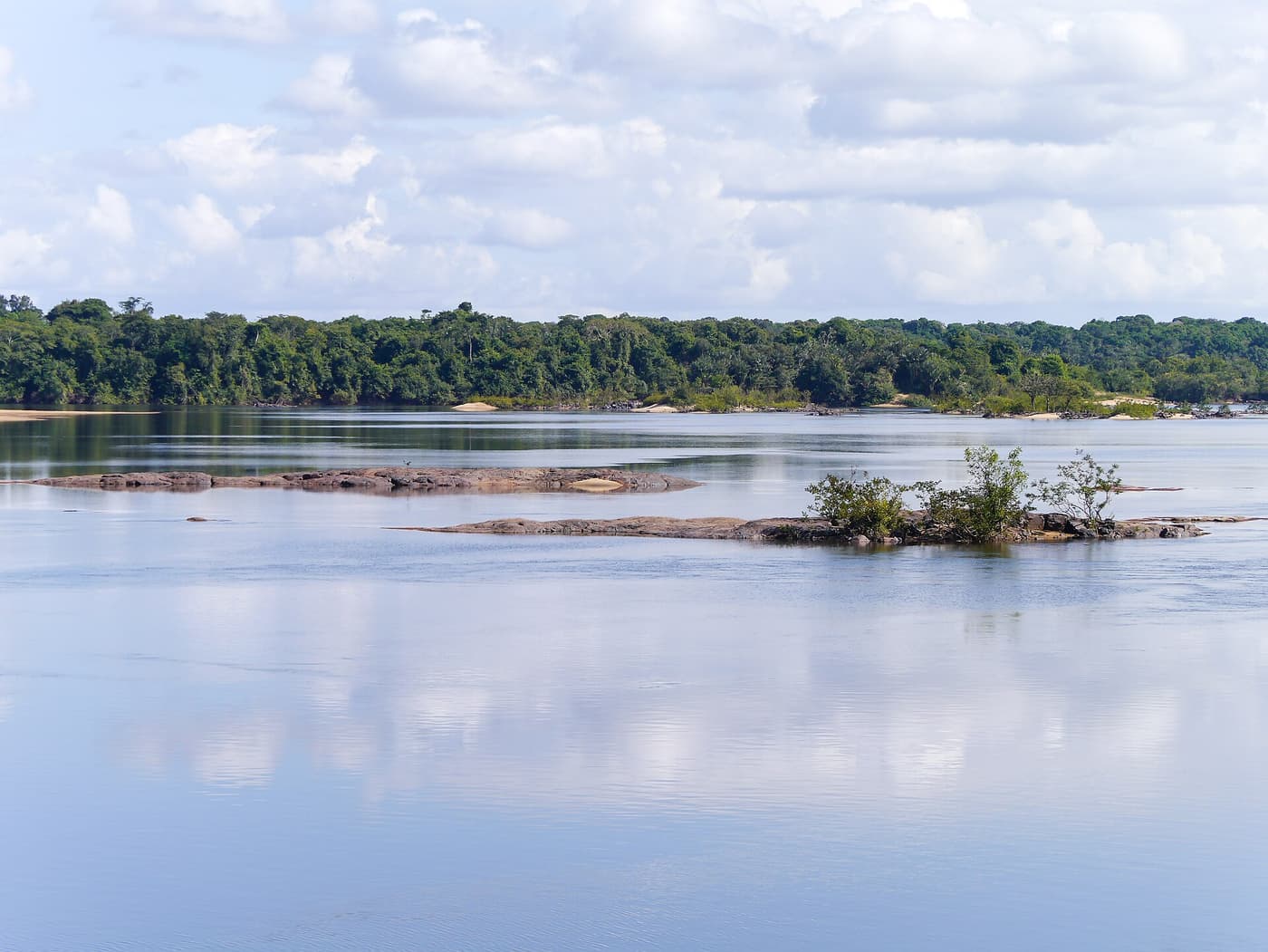 The wide Essequibo River at Iwokrama, with rocks and forested banks