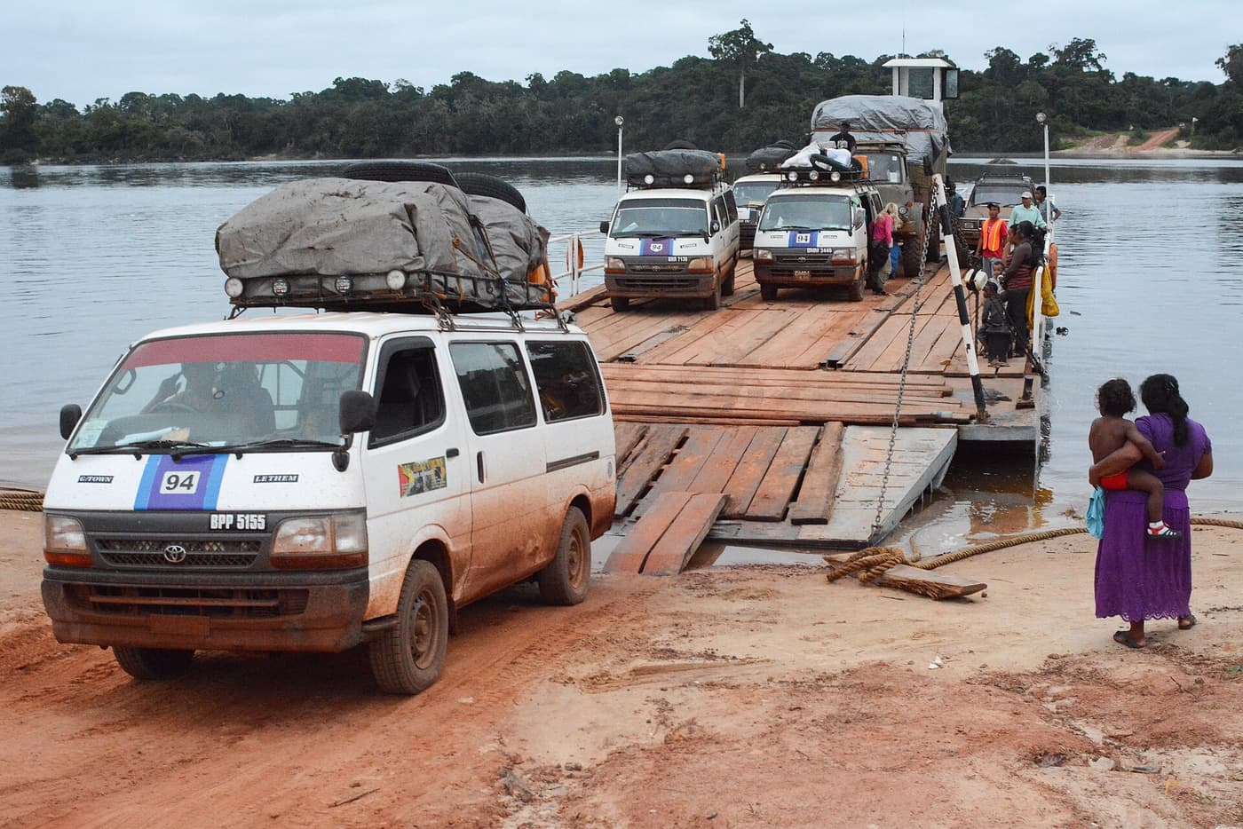 Minibuses driving off the wooden pontoon ferry at the Kurupukari crossing