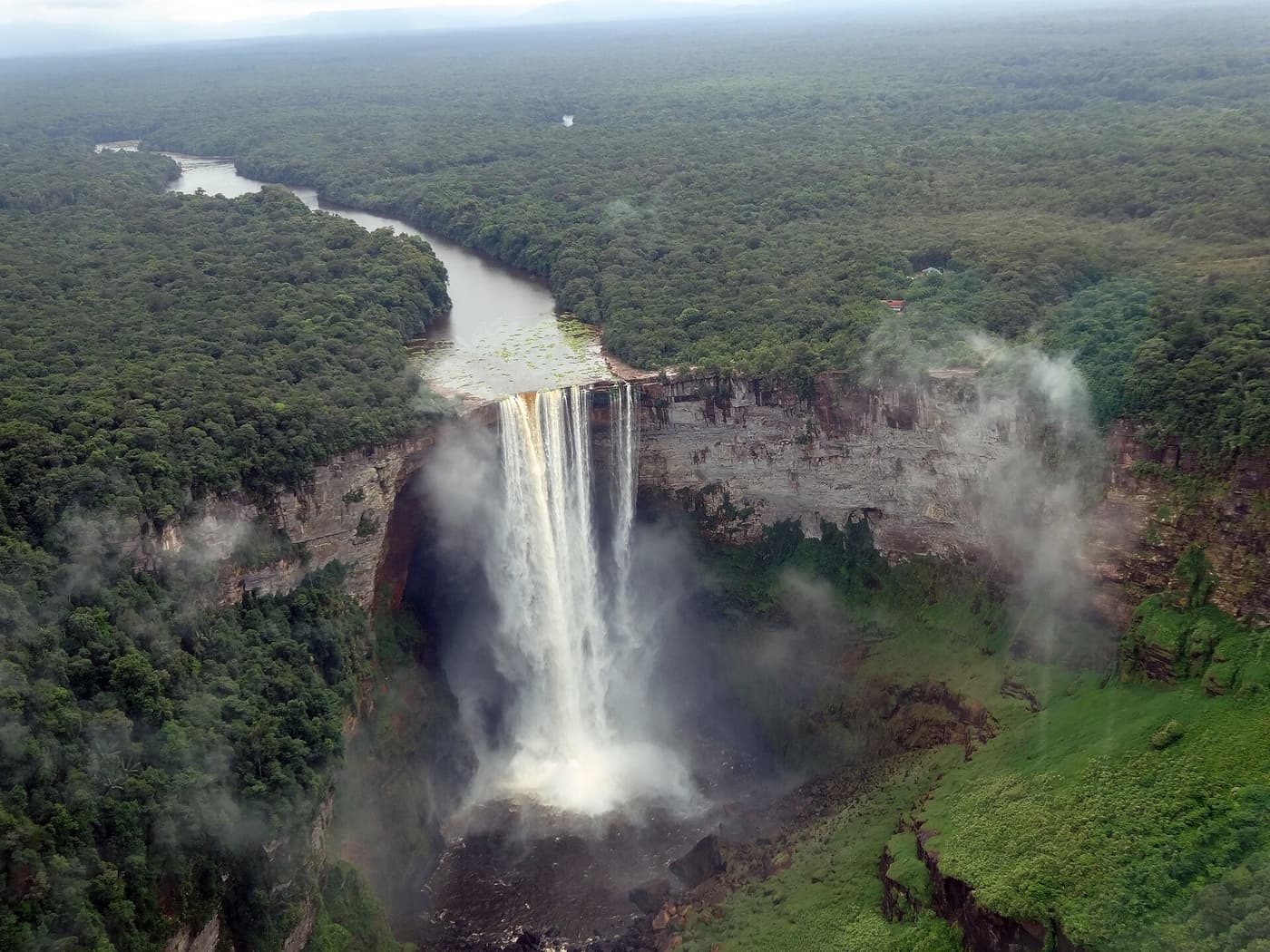 Kaieteur Falls and the Potaro River from the air, with spray drifting over the forest