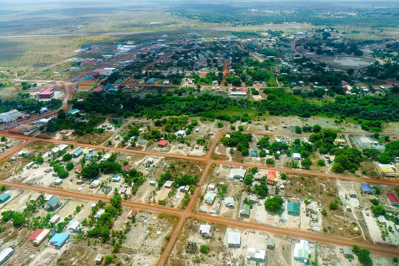 An aerial view of the streets and houses of Lethem on the savannah below the mountains