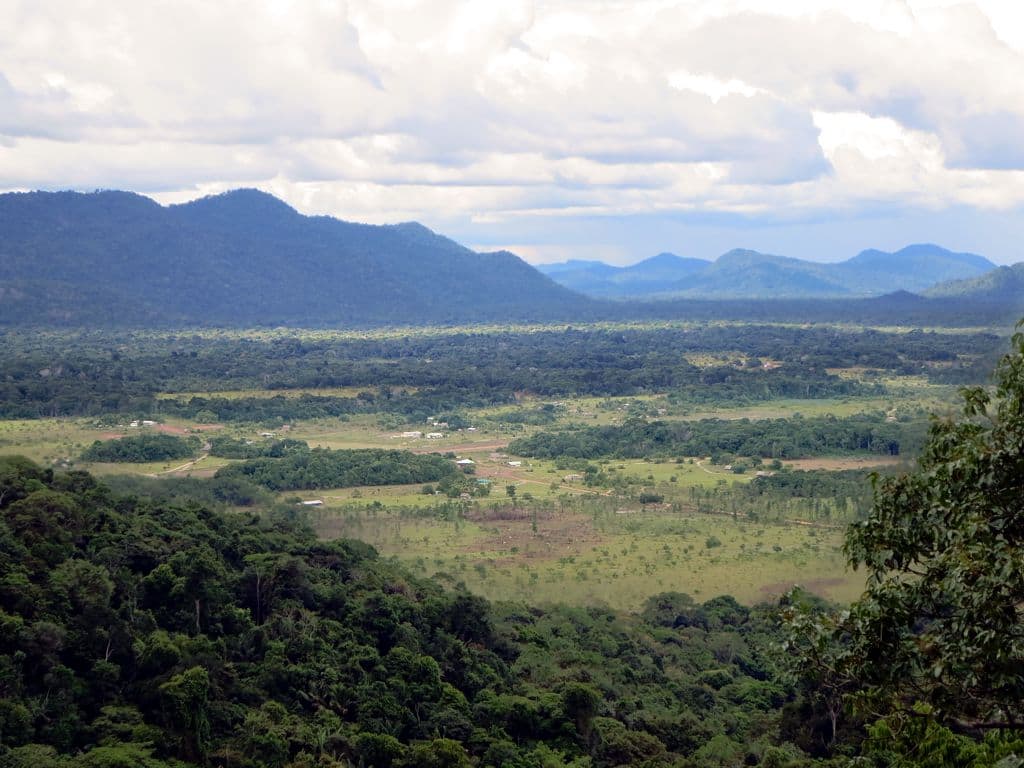 The view from Surama Mountain over patches of savannah and forest to distant blue hills